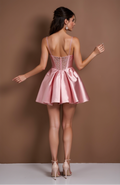 Blush pink satin mini dress with glitter lace bustier and flared pleated skirt.