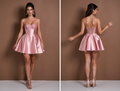 Blush pink satin mini dress with glitter lace bustier and flared pleated skirt.